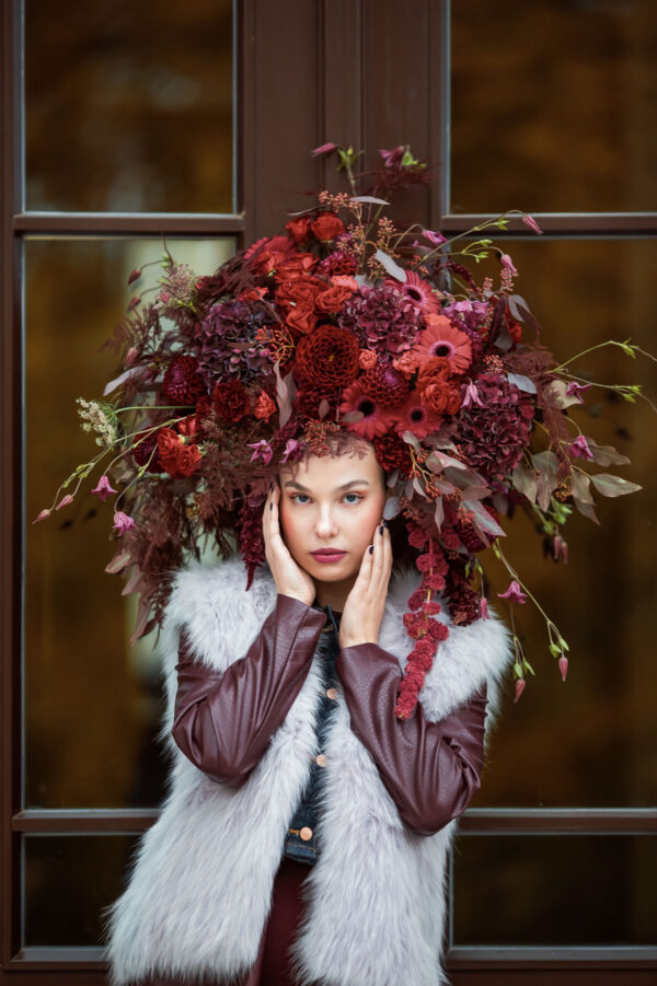 Künstlerisches florales Fotoshooting von Rose & Co mit einem Model und einer ausdrucksstarken Blumenpracht als Kopfschmuck
